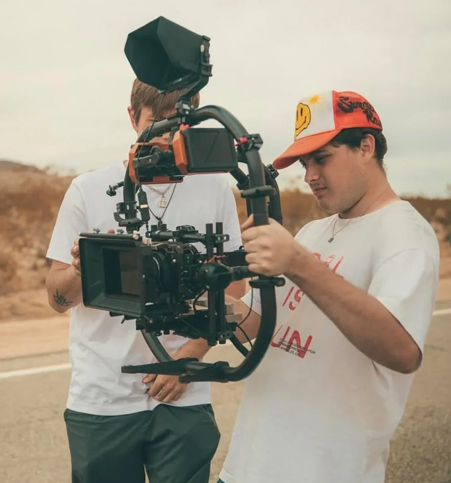 Two crew members setting up a cinema camera on a gimbal during a desert shoot